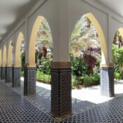 Moulay Ali Cherif's Mausoleum, arched colonnade overlooking a lush garden.