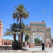 Rissani town center with ornate gate and palm trees.